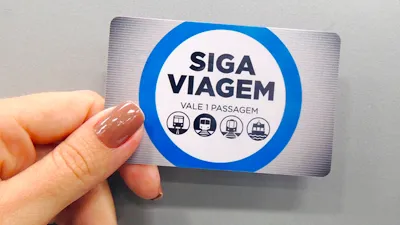 Mão de uma mulher segurando o cartão Siga Viagem