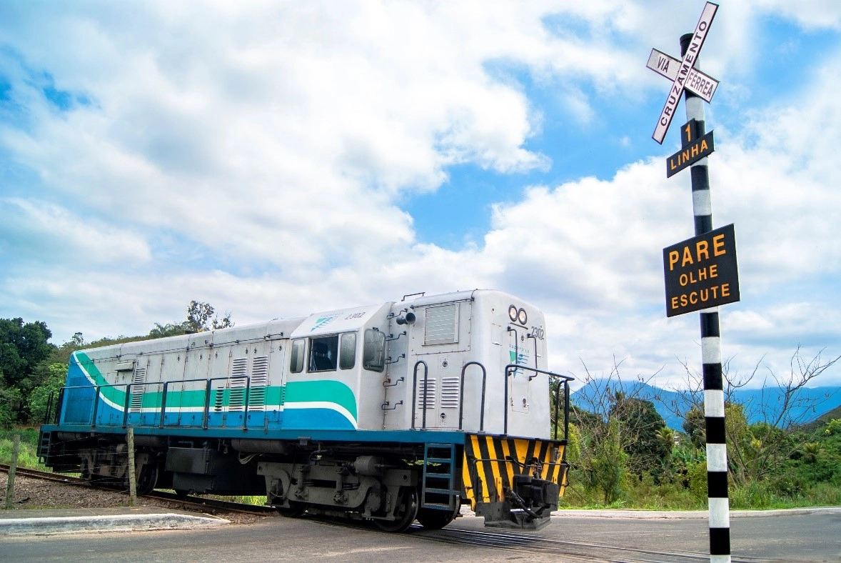 Trem da SuperVia passando por cruzamento com linha férrea